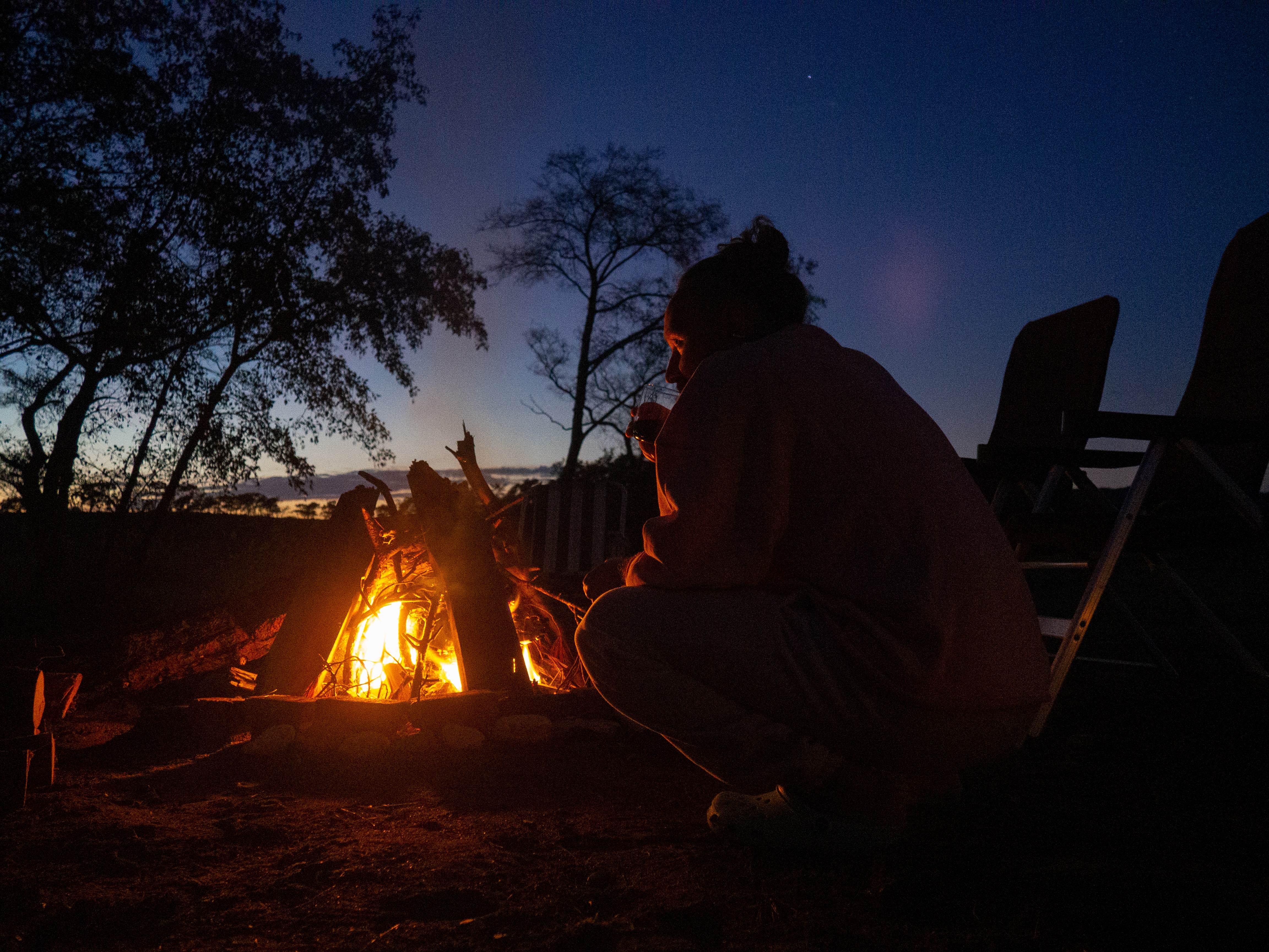 People Sitting Around Campfire In Dark Night Wallpapers