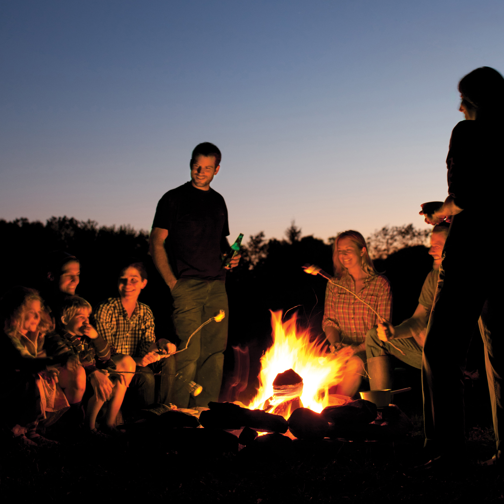 People Sitting Around Campfire In Dark Night Wallpapers