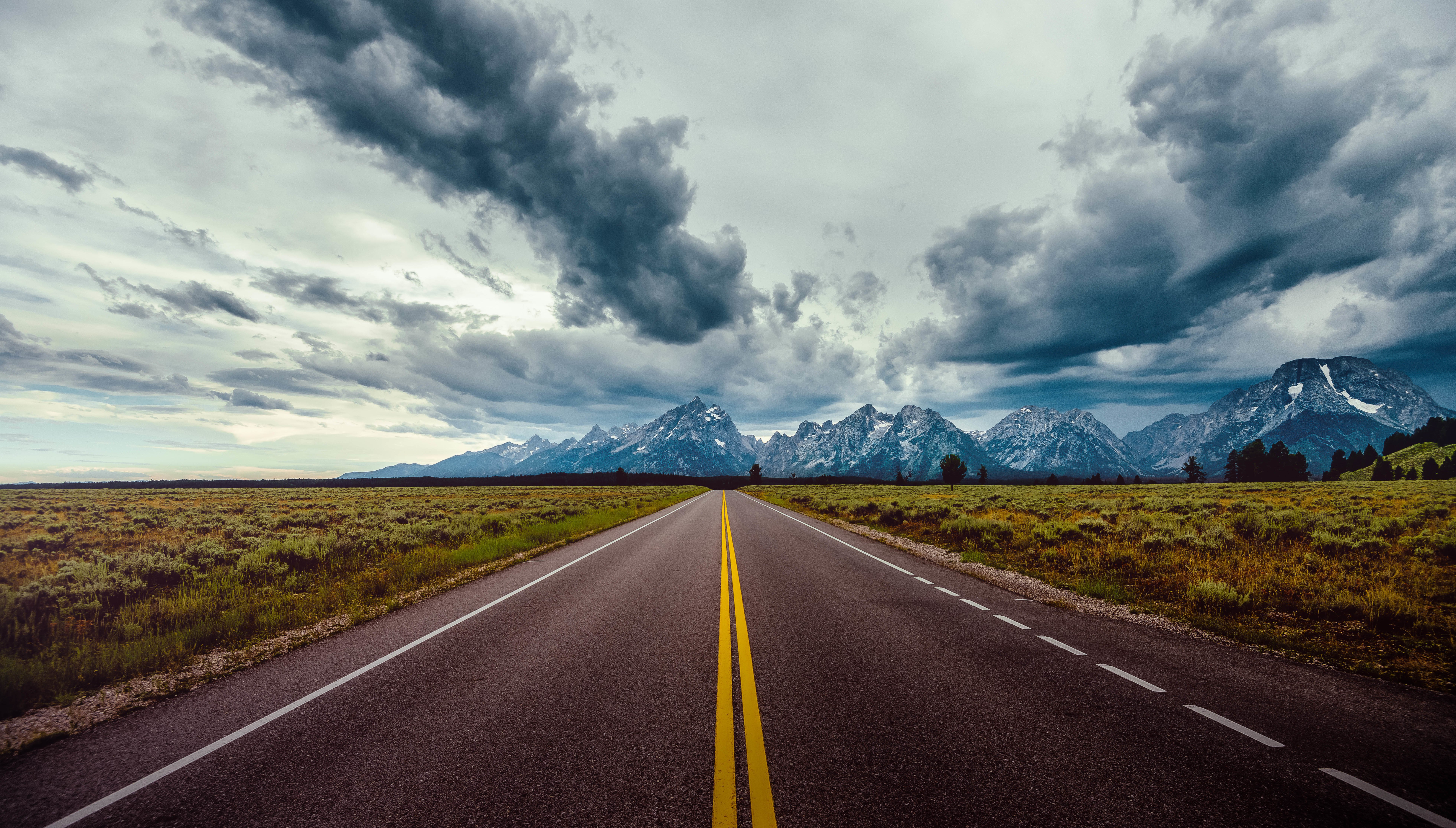 Road With Background Of Mountains And Clouds